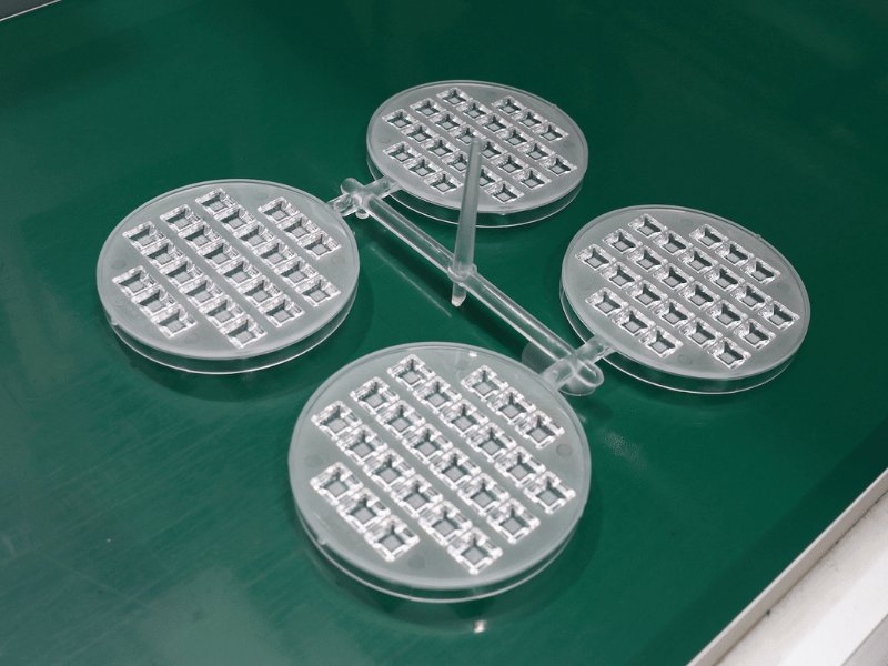Freshly moulded transparent polycarbonate LED lens arrays on the production line