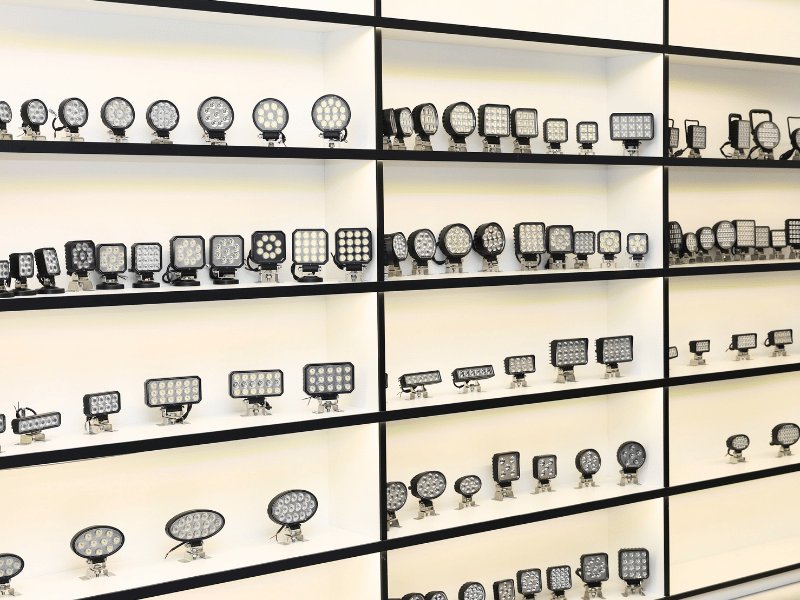 A showroom wall displaying LED work lights in multiple beam patterns and sizes